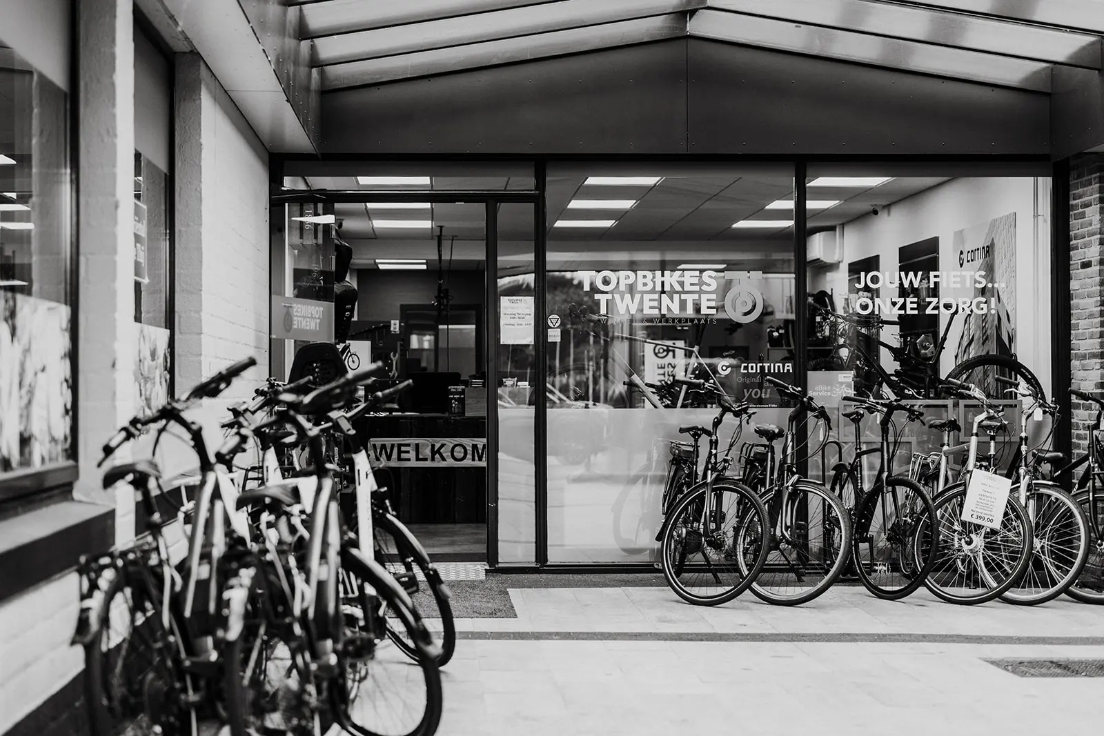 Foto van de voorkant van de fietsenwinkel in Oldenzaal. Foto is in zwart-wit.