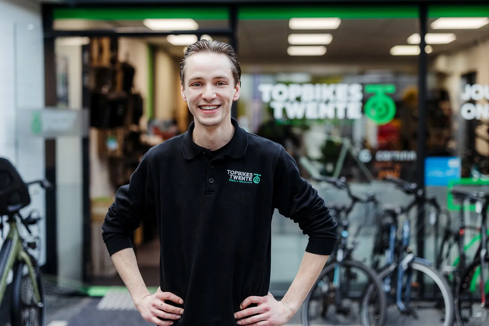 Luuk Segerink, eigenaar Topbikes Twente, die voor de fietsenwinkel in Oldenzaal staat met een glimlach.