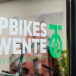 Voorkant van het raam bij Topbikes Twente, fietsenwinkel in Oldenzaal. Op het raam staat een sticker met logo van Topbikes Twente.