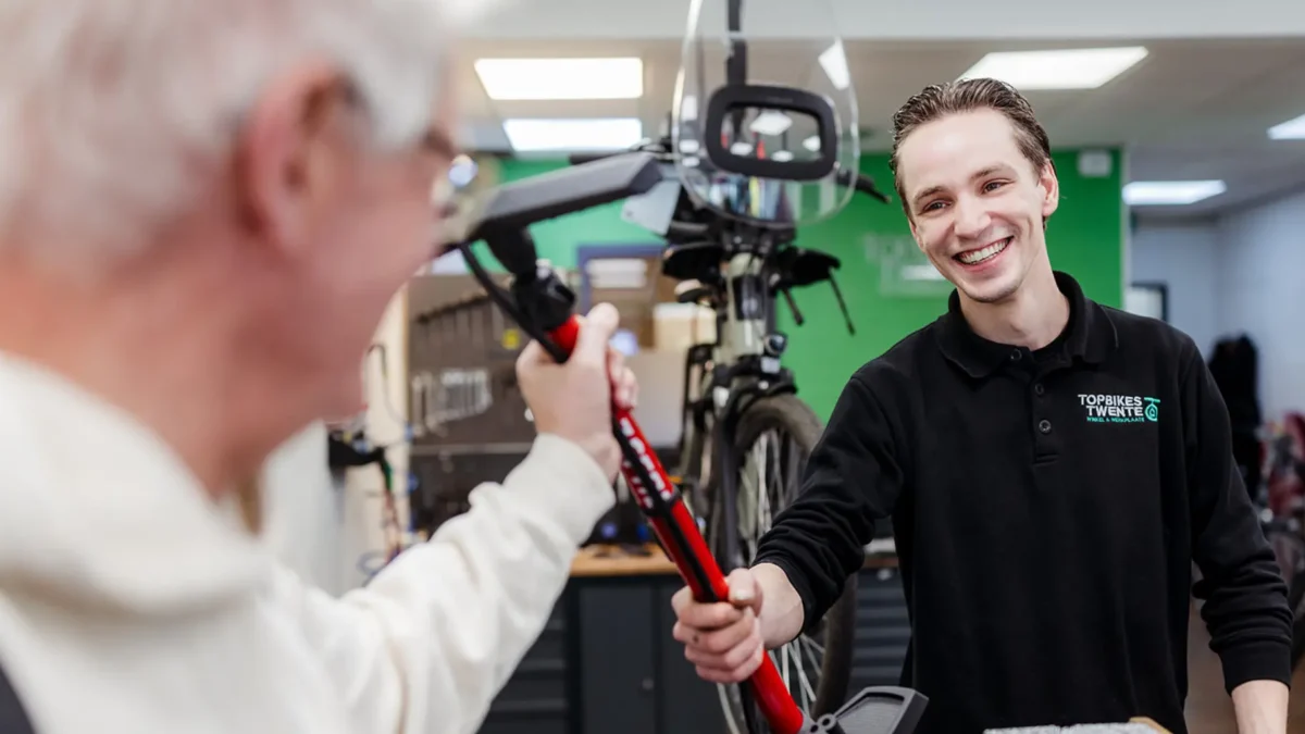 Klant neemt fietspomp aan bij aankoop tweedehands fiets in Oldenzaal.