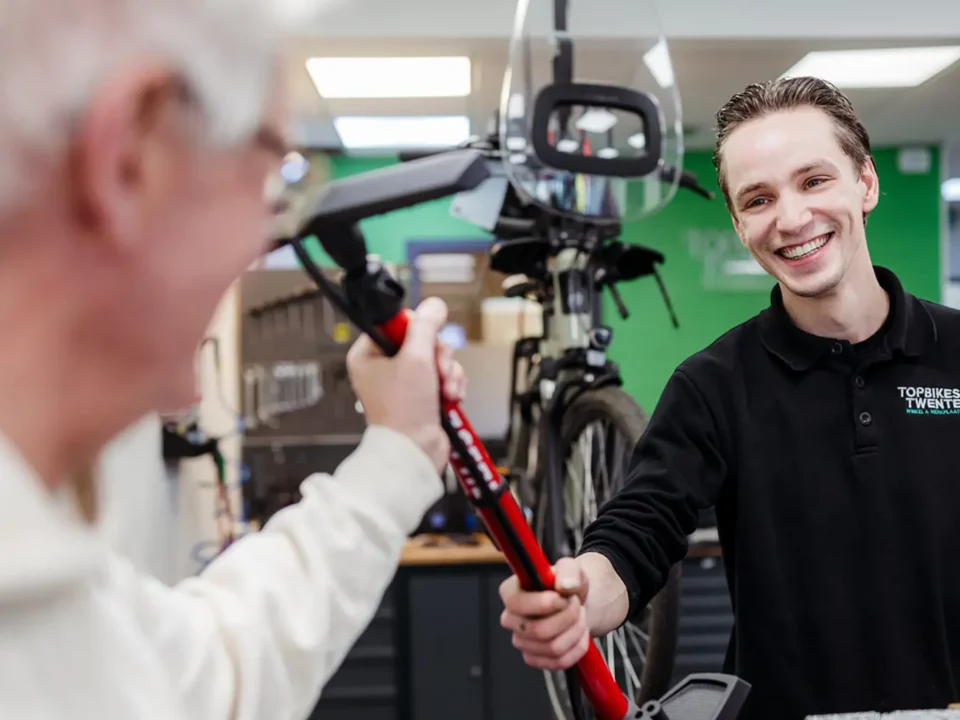 Klant neemt fietspomp aan bij aankoop tweedehands fiets in Oldenzaal.